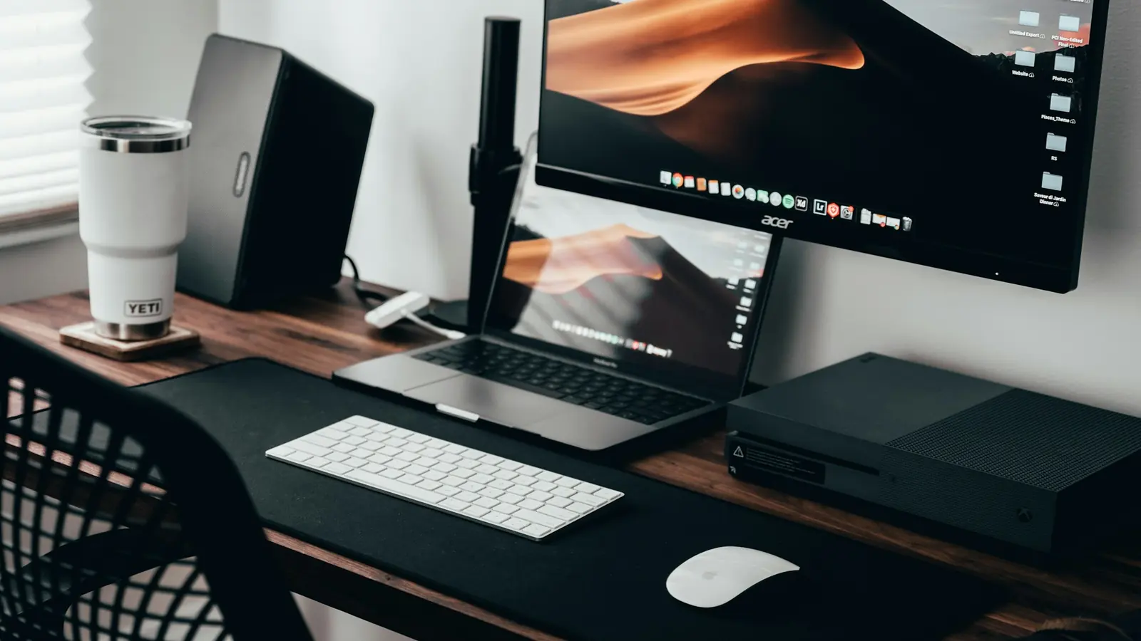 A home office desk with a laptop and an external monitor