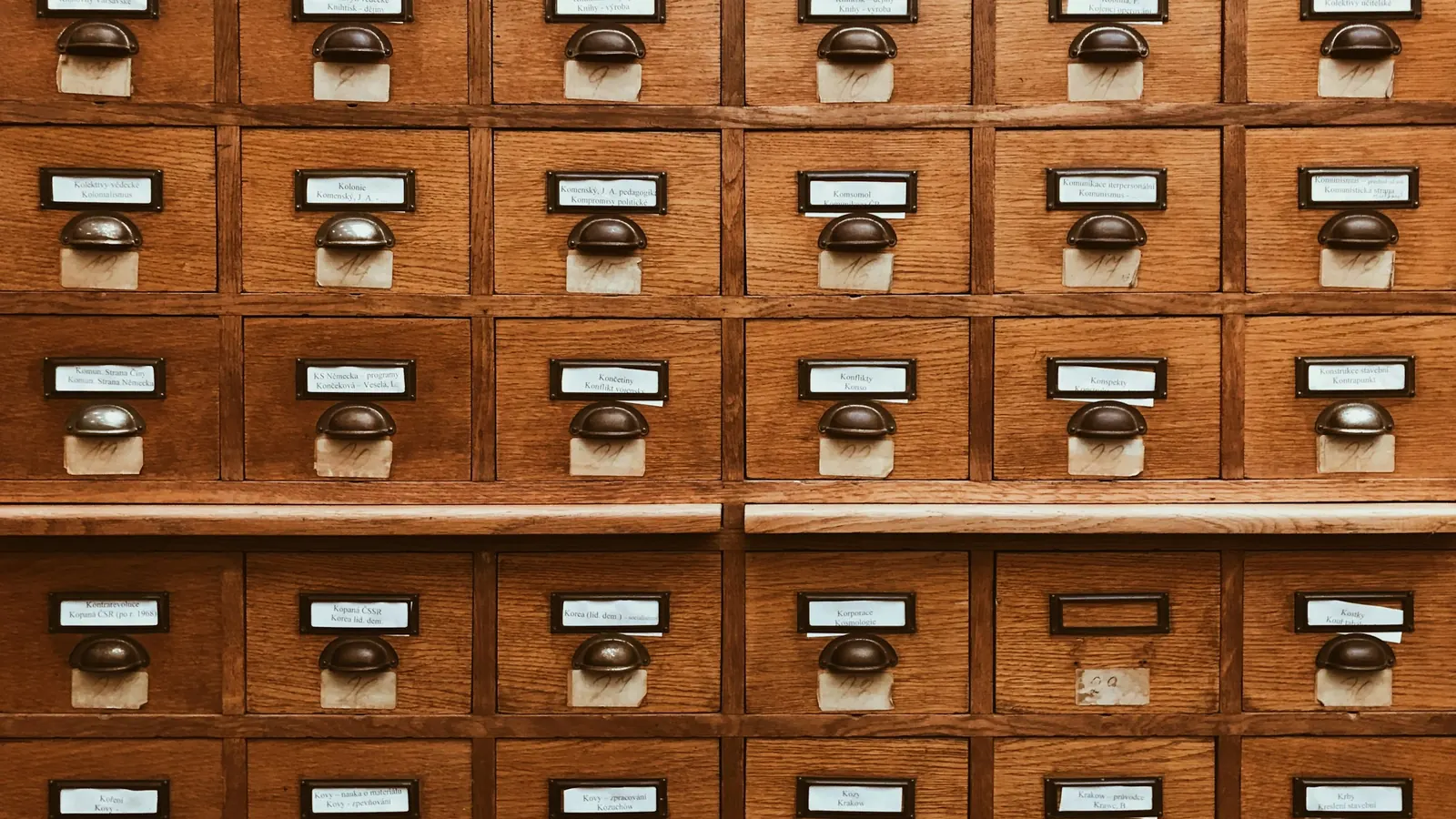 Rows of labelled wooden drawers in a library card catalogue